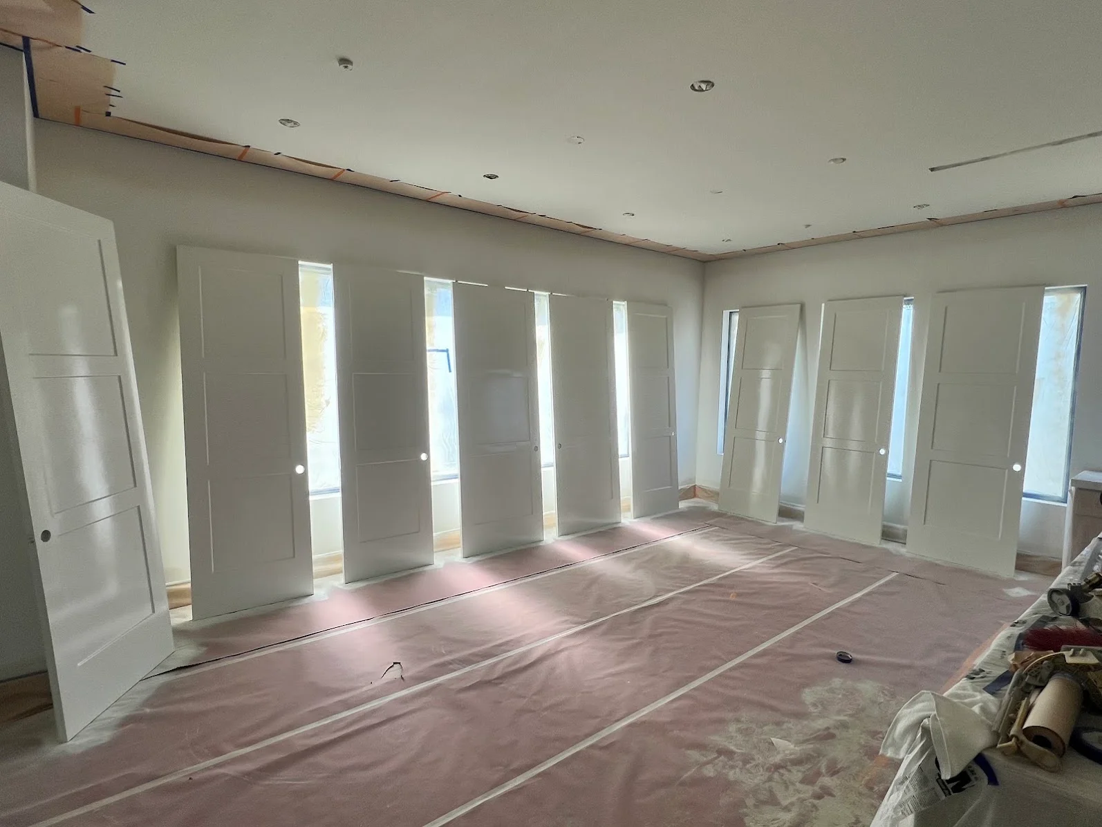 White drywall walls and ceiling with installed interior glass doors and recessed lighting