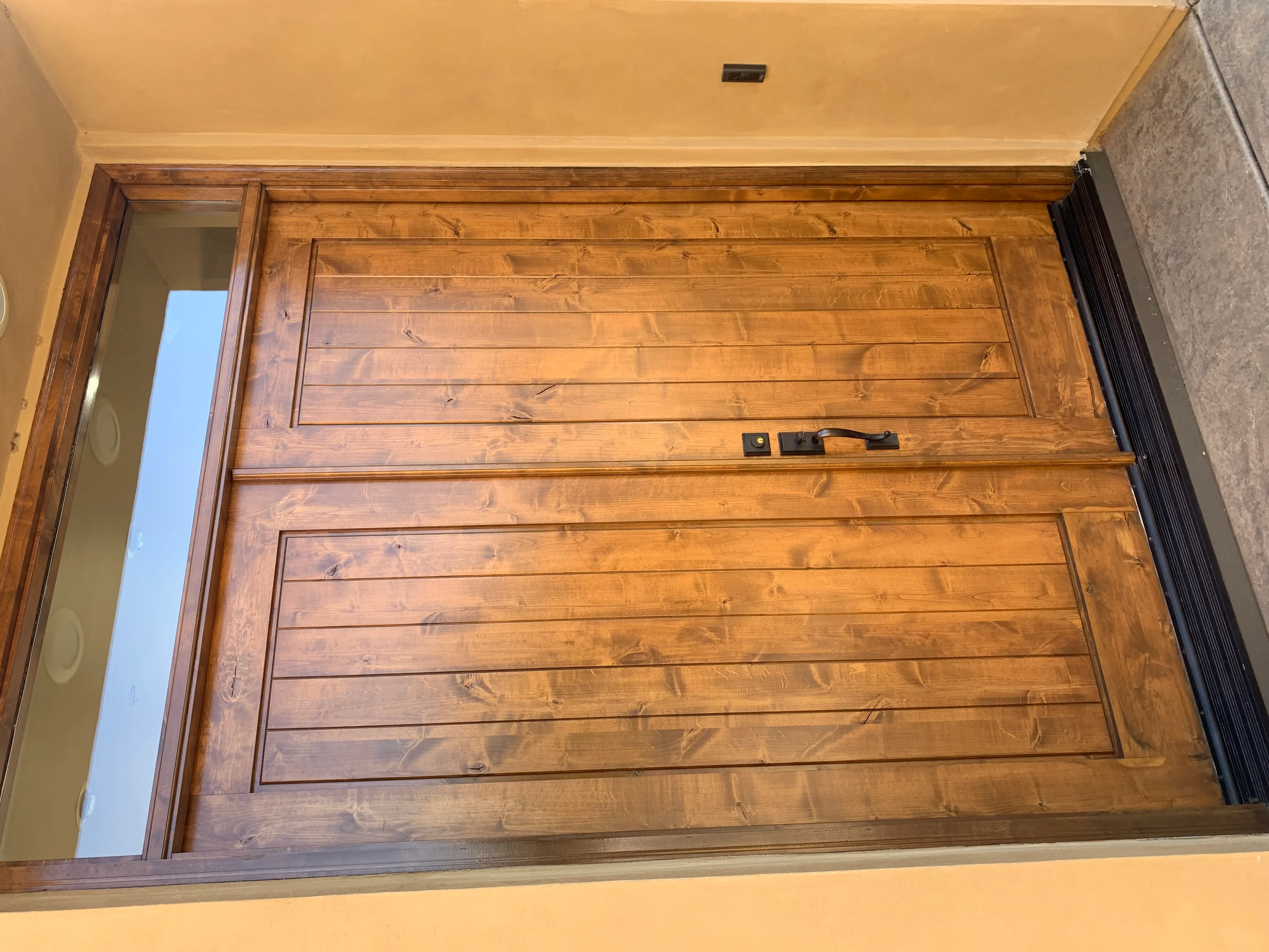 Overhead view of finished wood shiplap ceiling with horizontal boards and decorative trim panels