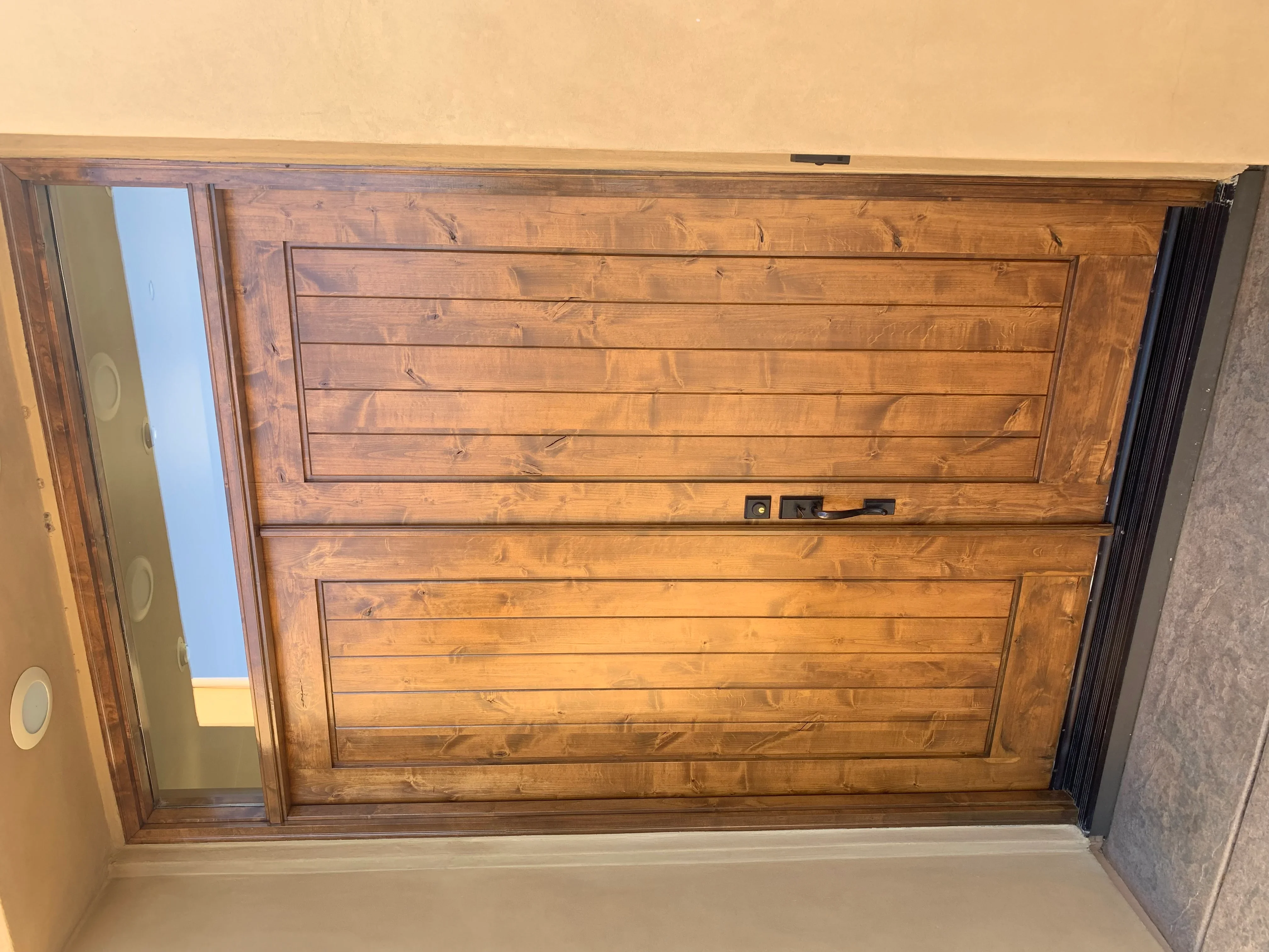 Refinished wooden garage door with horizontal planks and warm honey stain finish