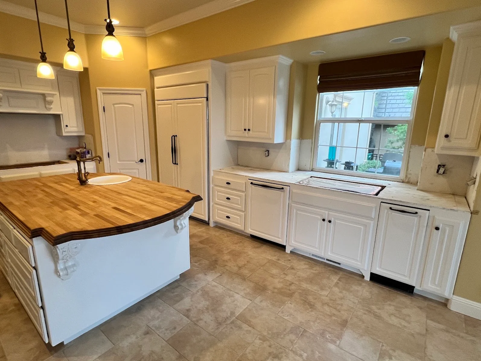 Yellow kitchen walls with white painted cabinets, island, and trim work