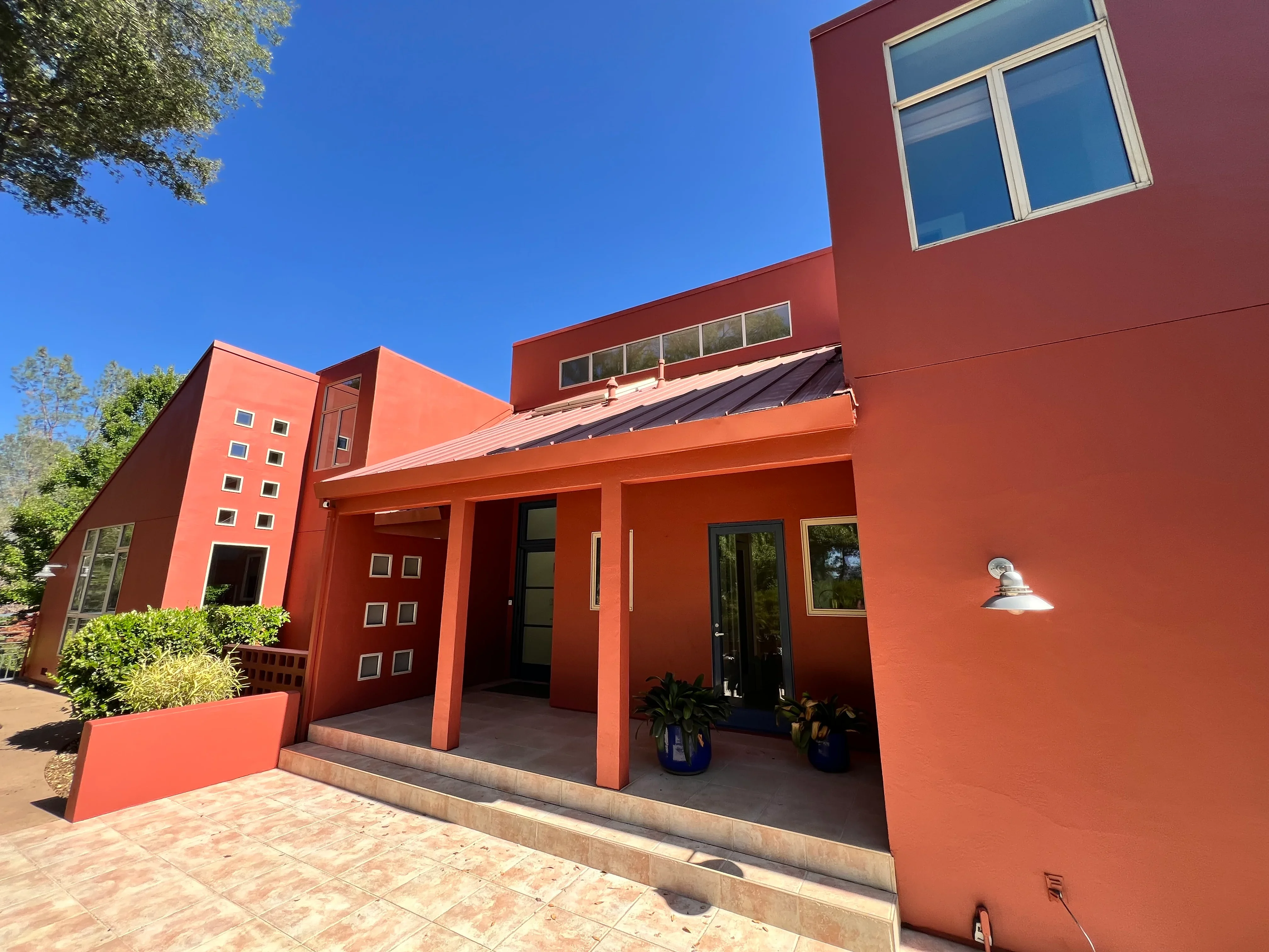 Modern red stucco home with covered entry portico and contemporary architecture in El Dorado Hills