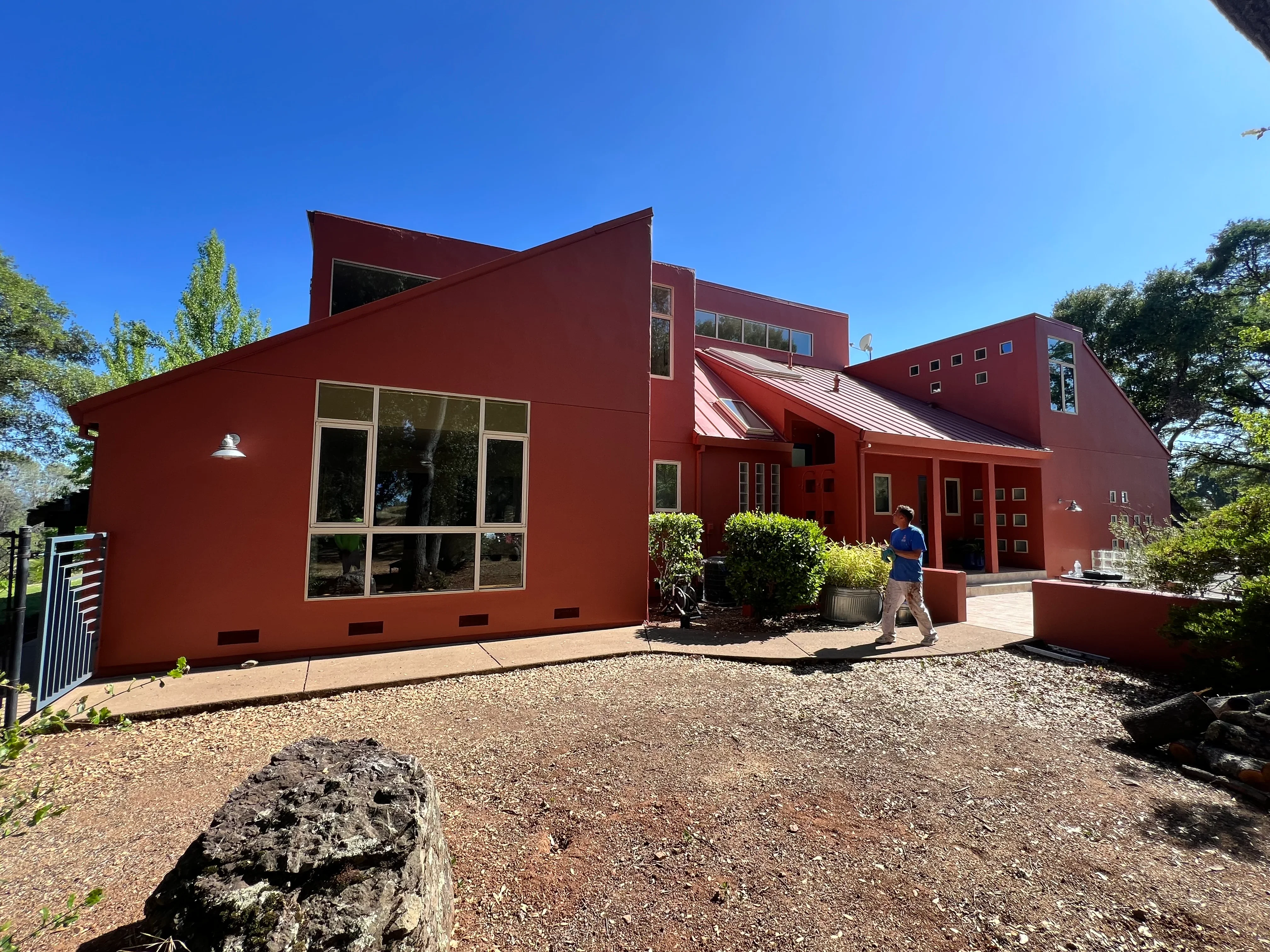 Modern rust-red painted residential home with geometric architecture and large windows
