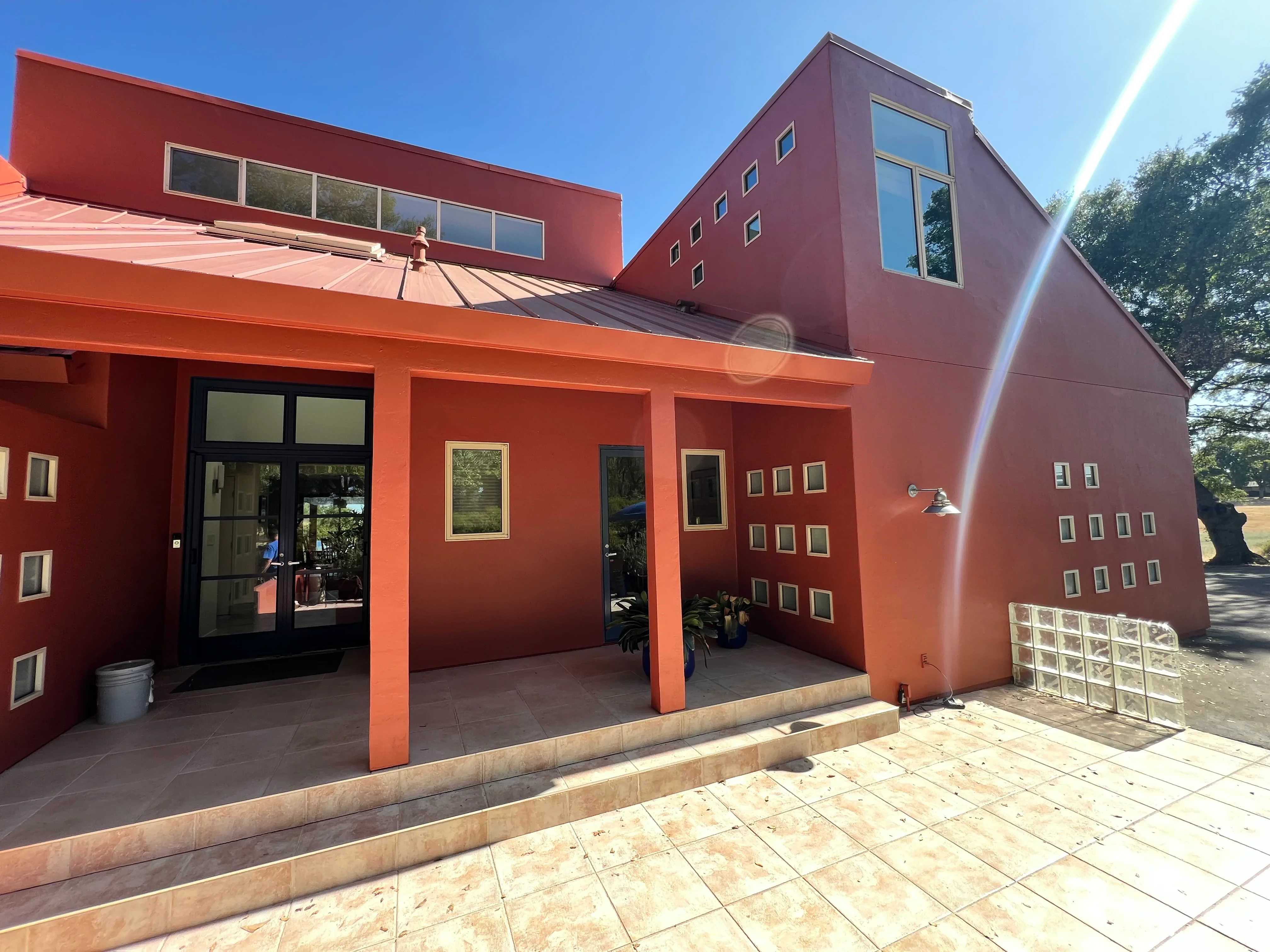 Modern commercial building with rust-orange and burgundy exterior paint and geometric window design