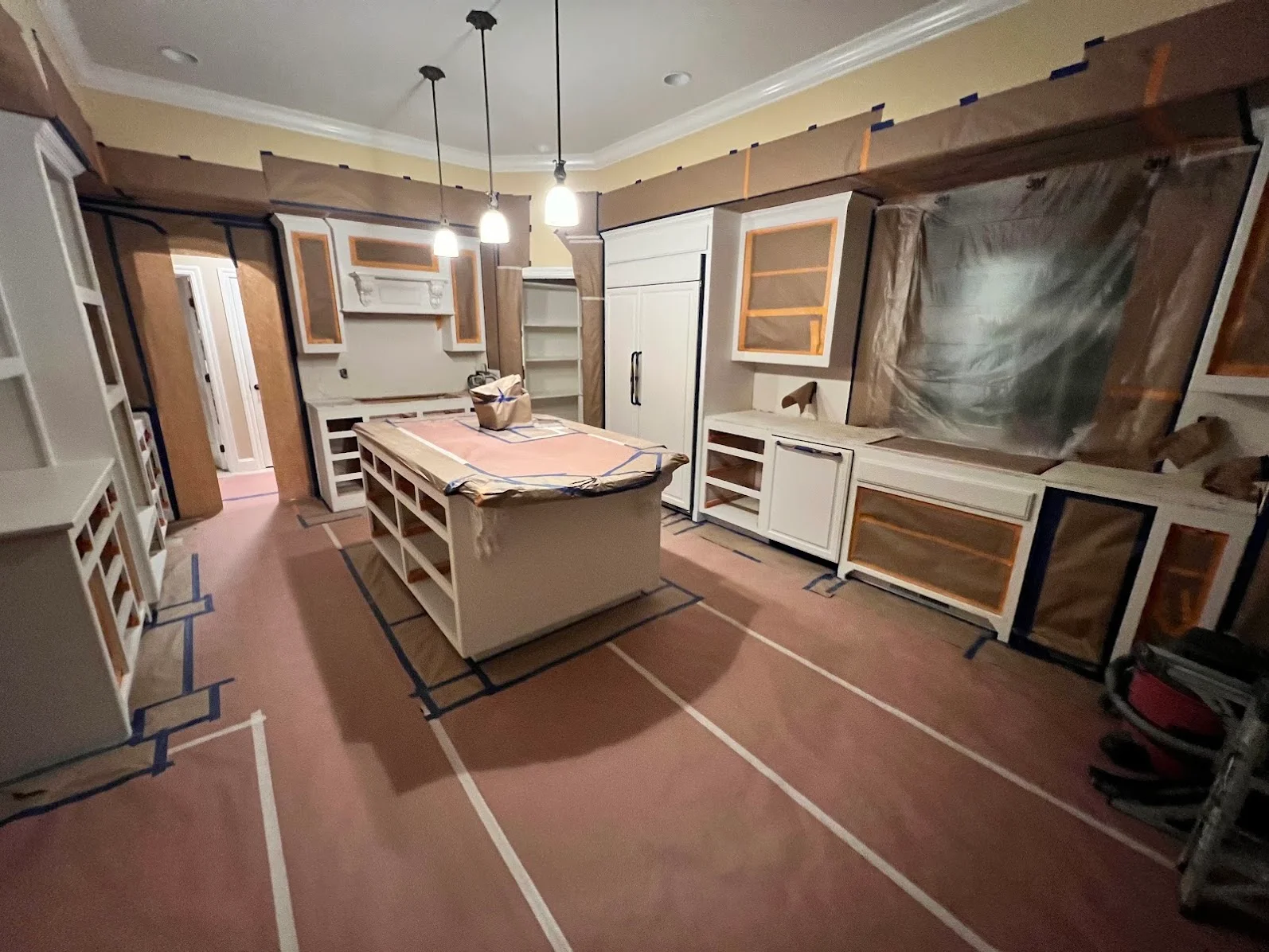 Bathroom interior with painted walls, white ceiling, custom painted cabinets, and pendant lights during renovation