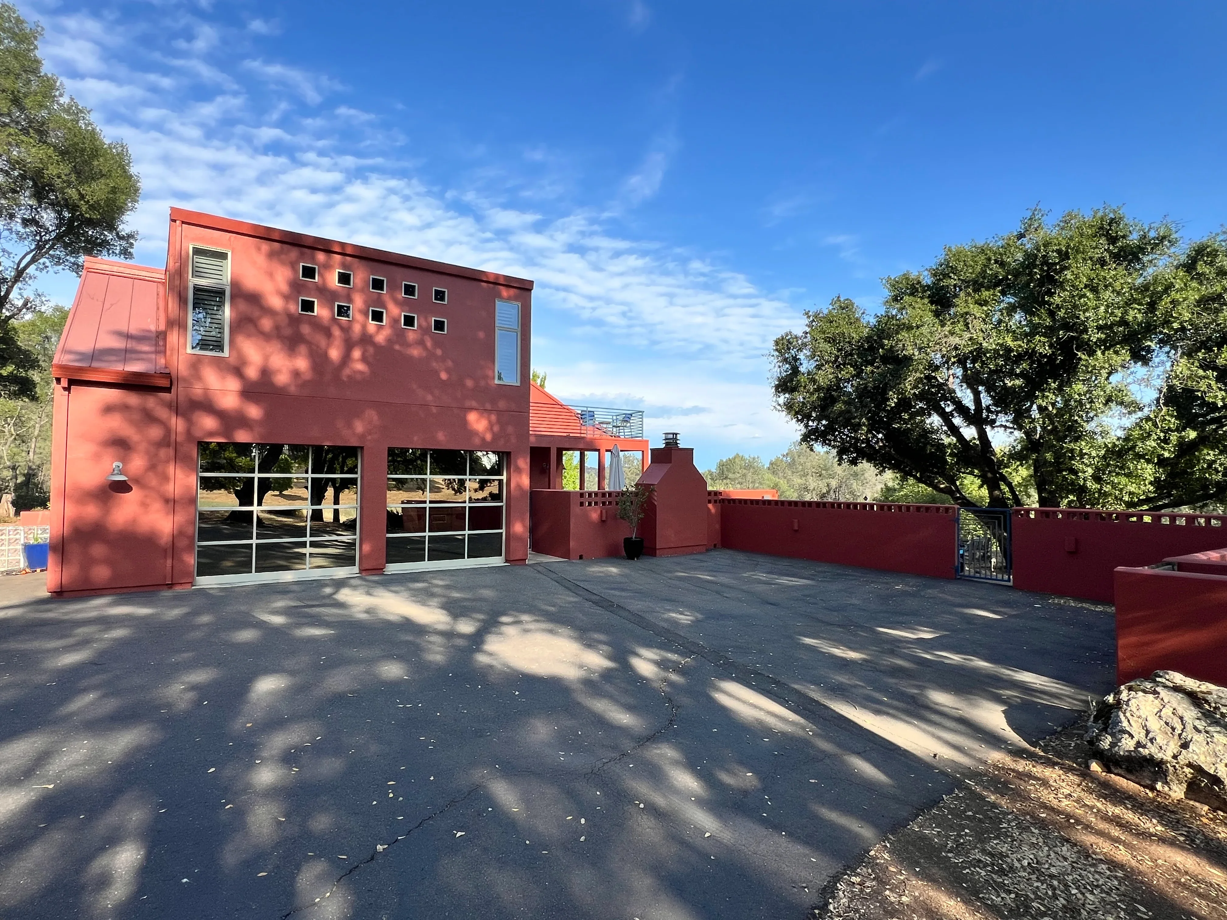Modern red-painted house with matching garage doors and fence in El Dorado Hills