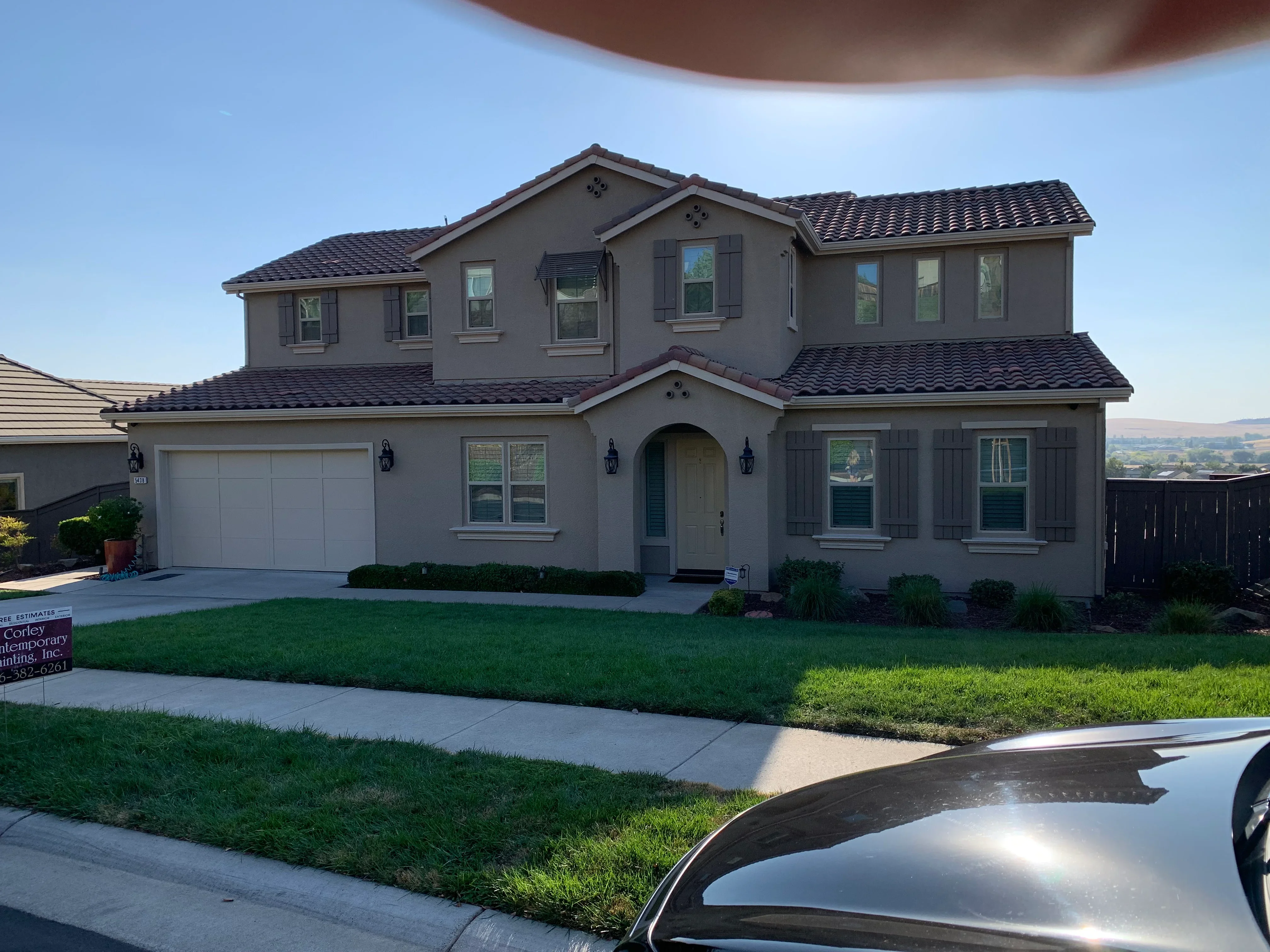Two-story taupe stucco home with dark roof and gray shutters in El Dorado Hills