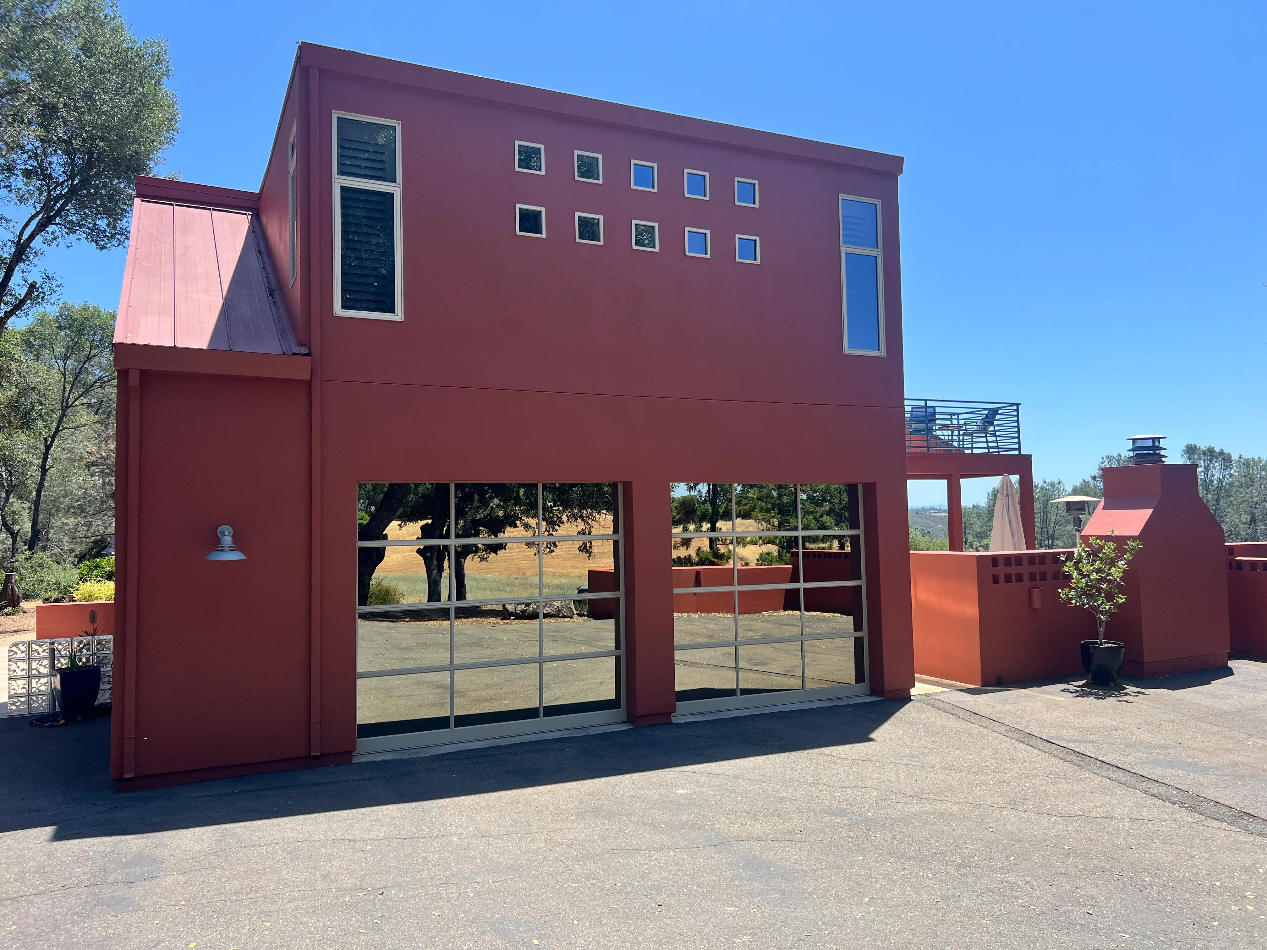 Modern home with wine red painted exterior and large black-framed windows