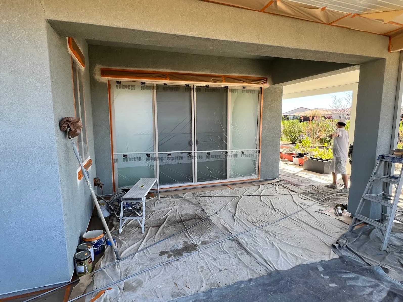 Interior drywall finishing with concrete walls, wood beams, and glass sliding door installation preparation